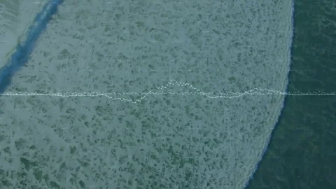 Overhead wave crest appearing left initiating foam spreading right while Stock Footage 312713875