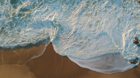 Overhead waves breaking on beach in summer, as camera pulls back Stock Footage 95139204