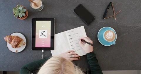 Overhead of woman using foreign language learn chinese mobile phone app Video stock 90312138