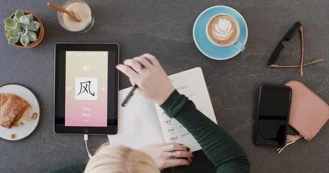 Overhead of woman using new language learning app on mobile tablet device Stock Footage 90314563