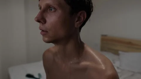 Overheated sweating man feeling exhausted and uncomfortable in hot room 스톡 동영상 346251541