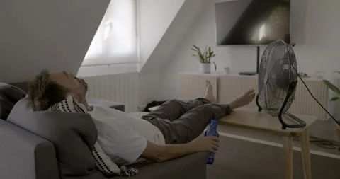 Overheating man on sofa: Stock Footage 336139723