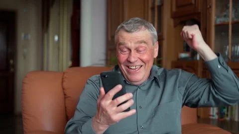 Overjoyed elderly man hold phone look screen excited about mobile app sport bet Stock Footage 152714554