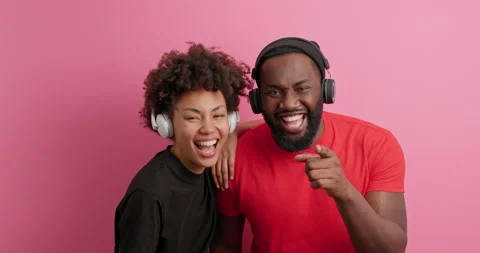 Overjoyed happy dark skinned young girlfriend and boyfriend point at camera Stock Footage 149916848