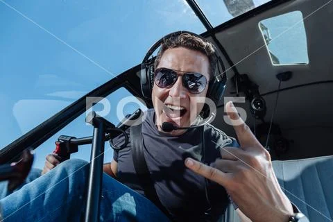 Overjoyed helicopter pilot showing sing of horns Stock Photos