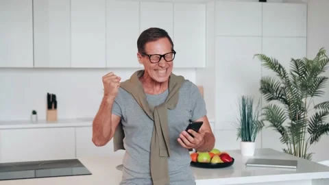 Overjoyed laughing middle aged 60s retired man looking at cellphone screen Stock Footage 219548981