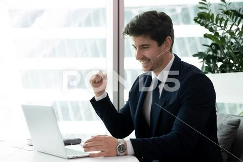 Overjoyed male employee read good news on laptop Stock Photos
