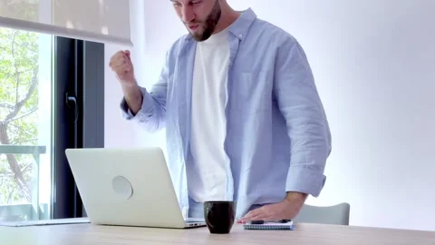 Overjoyed man working on a laptop computer feeling euphoric after reading good Stock Footage 346870618