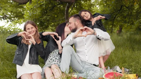Overjoyed parents and two pretty daughters showing love sign with fingers while Stock Footage 157557861