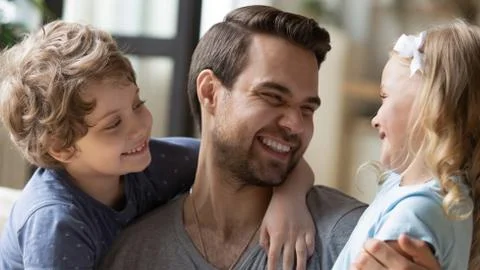 Overjoyed young dad have fun with little kids Stock Photos