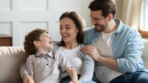 Overjoyed young family with child relax at home Stock Photos