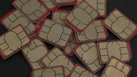 Overlapping Array of SIM Cards with Red Borders on Dark Surface 動画素材 338409466