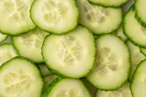 Overlapping cucumber slices fill the frame in a fresh green pattern. Stock Photos