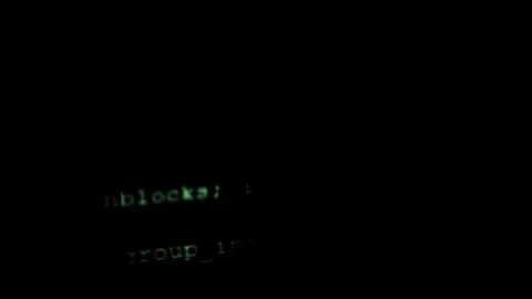 Overlapping lines of code scroll down on the monitor. Stock Footage 121983395