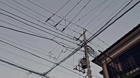 Overlapping Power Lines Stretching Between Utility Pole and Residential Stock Footage 338398618