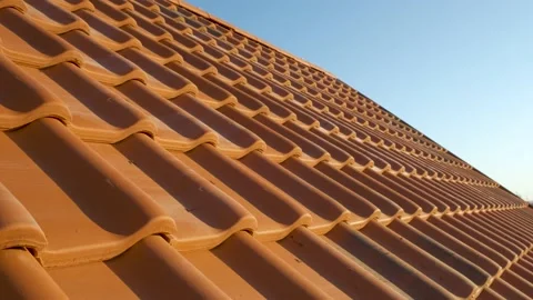 Overlapping rows of yellow ceramic roofing tiles covering residential building Stock Footage 152969920