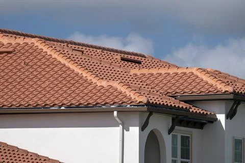 Overlapping rows of yellow ceramic roofing tiles covering residential building Foto stock