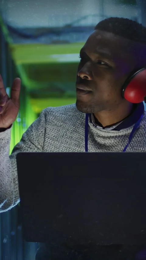 Overlay dots appearing, technician studying laptop, pointing to server racks Stock Footage 332845718