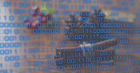 Overlaying blue binary digits obscuring office desk with slatted scanlines and Foto stock