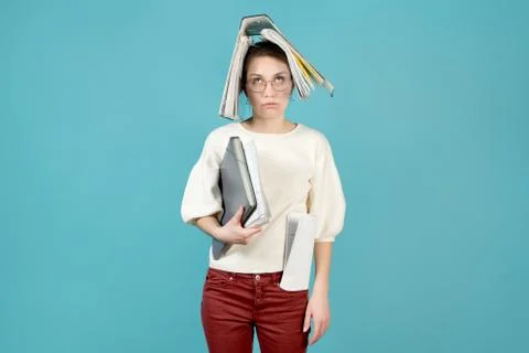 Overloaded office worker with a folder of documents on her head. Stock Photos