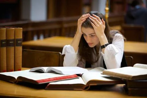 Overloaded student in library Stock Photos