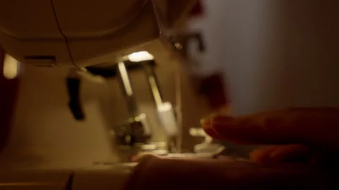Overlock Sewing Machine Operation in Progress. Hands guiding fabric through an Stock Footage 264381128