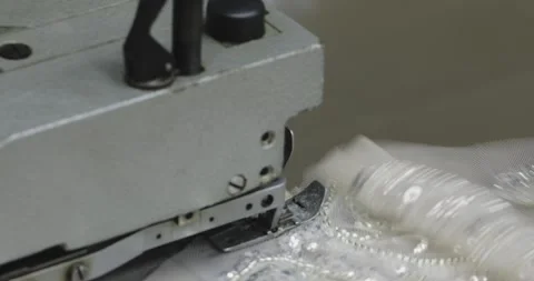 Overlock sewing machine sews white beaded fabric. macro Stock Footage 171997525