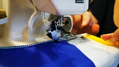 Overlock sewing. Making garlands of flags. The process of sewing on the overlock Stock Footage 120254572