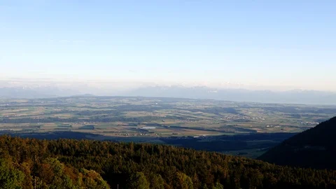 Overlooking forests, valley, and mountain range of the French Alps at sunrise. Video stock 116400941