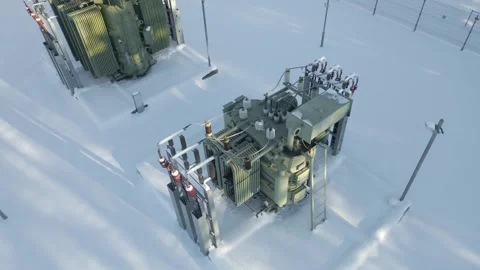 Overlooking Outdoor Power Transformers in Snow Covered Electrical Substation 動画素材 331034877