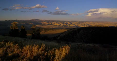 Overlooking a vast valley in the open range of the American West as the sunsets Stock Footage 60824779