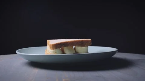 Overly dramatic shot of a peanut butter and banana sandwich. Видео 142774338