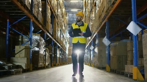 Overseer Wearing Hard Hat with Tablet Computer Counts Merchandise in Warehouse.  Video stock 74373466