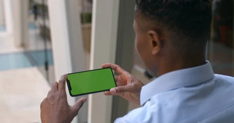 Overshoulder view of afro american guy holding phone in horizontal landscape Video stock 130045486
