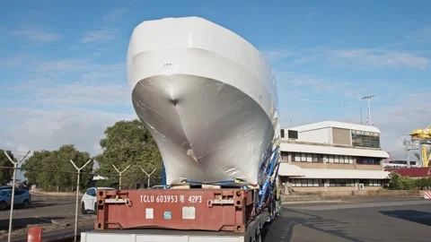 Oversized Boat Hull Transport on Flatbed Truck at Industrial Dockyard. Stock Footage 334250448