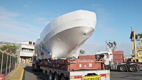 Oversized Boat Hull Transported on Trailer at Industrial Shipping Dock. Stock Footage 334250553