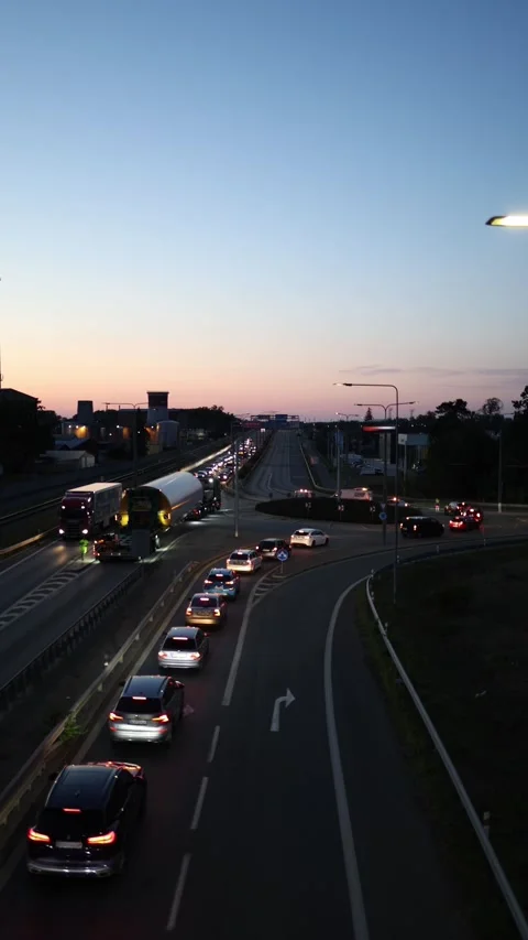 Oversized cargo transport blocks traffic on an urban road at dusk Stock Footage 342444310