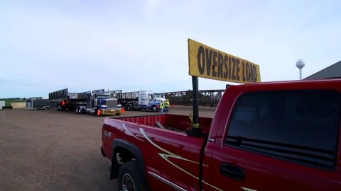 An oversized load and it's escort prepare to pull out in slow motion. Stock Footage 93713795