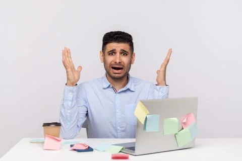 Overtime, overwork concept. Shocked scared man employee sitting in office wor Stock Photos
