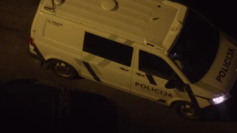 Overturned police van lying on roadside at night with damaged body and dark Stock Footage 345269363