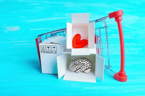 Overturned push cart with human brain and heart Stock Photos