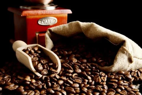 Overturned sack full of coffee beans isolated on black with spatula and winno Foto stock