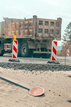 Overturned stop sign in front of a heavy construction truck at a roadwork s.. Stock Photos