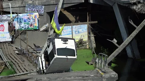 An overturned van at the destroyed bridge at Irpin, which is credited with Stockbeeldmateriaal 221256619