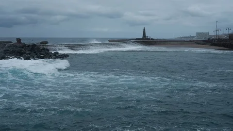 Overview of big ocean waves hits breakwater at shore of city in Bajamar Video stock 122966965