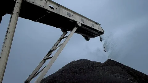 An overview of a coal falling from the belt conveyor at the coal mine Stock Footage 101502097