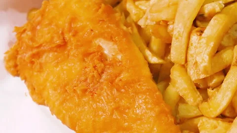 Overview of Delicious British Fish and Chips in Traditional White Paper with Stock Footage 321797715