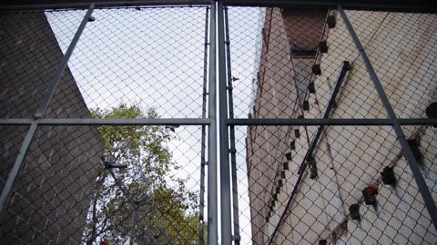 Overview of the prison gates with electric barbed wire and a massive lock Stock Footage 165052503