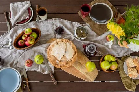 Overview of rectangular wooden table served with homemade pie and other food Stock Photos