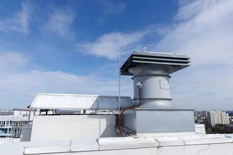 Overview of Rooftop Ventilation System with Clear Sky and Cityscape in the Stock Photos